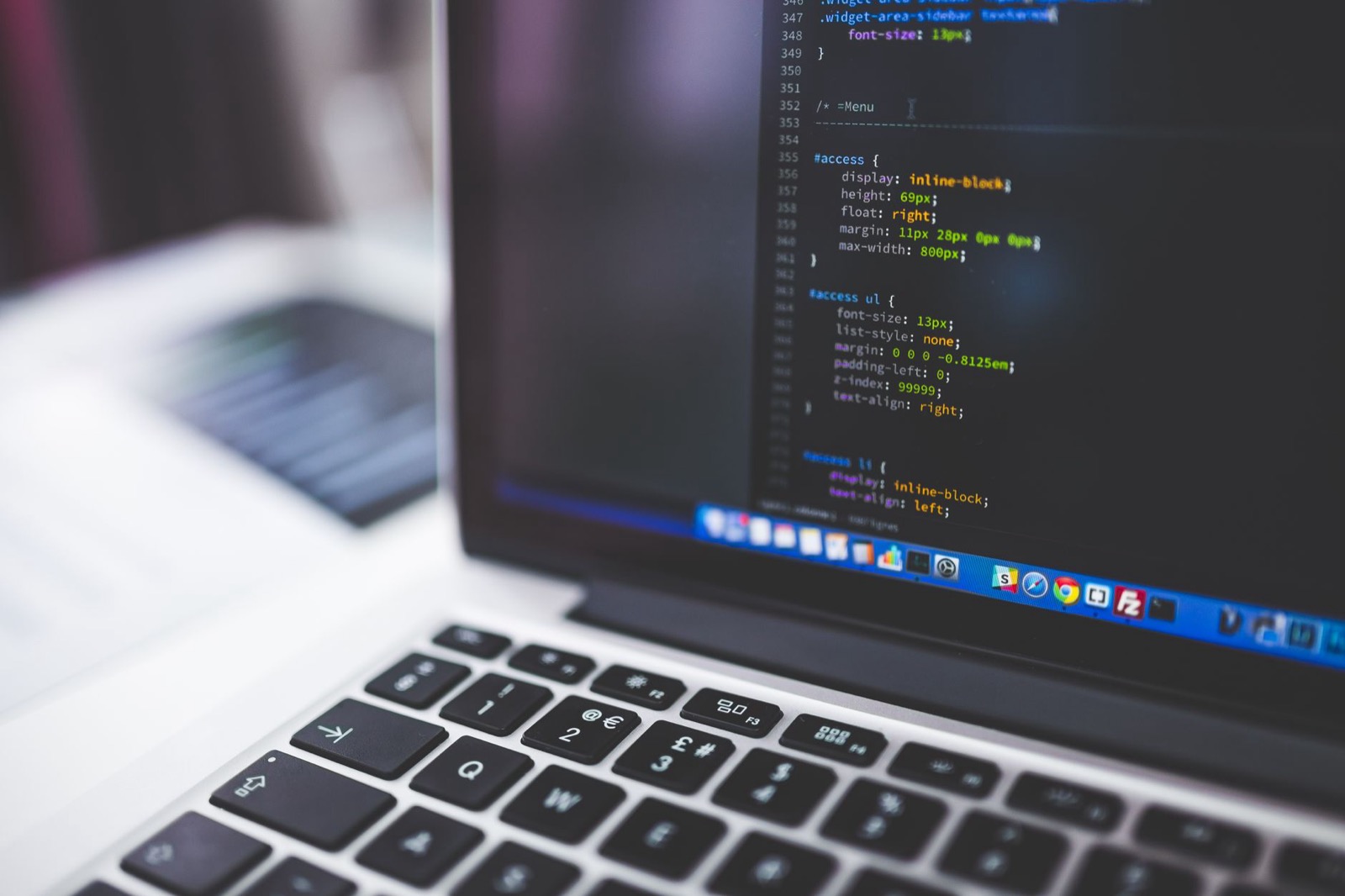 HTML code on a laptop screen — the technical layer AI crawlers read before they ever quote your site